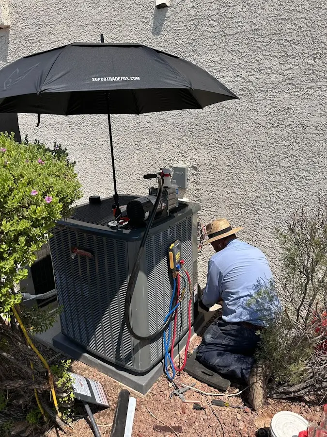 HVAC technician performing outdoor AC maintenance in Scappoose