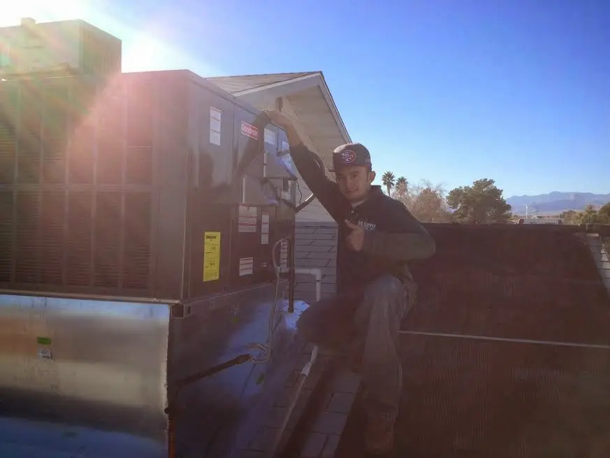 HVAC technician performing AC Tune-Up on a rooftop unit in Scappoose